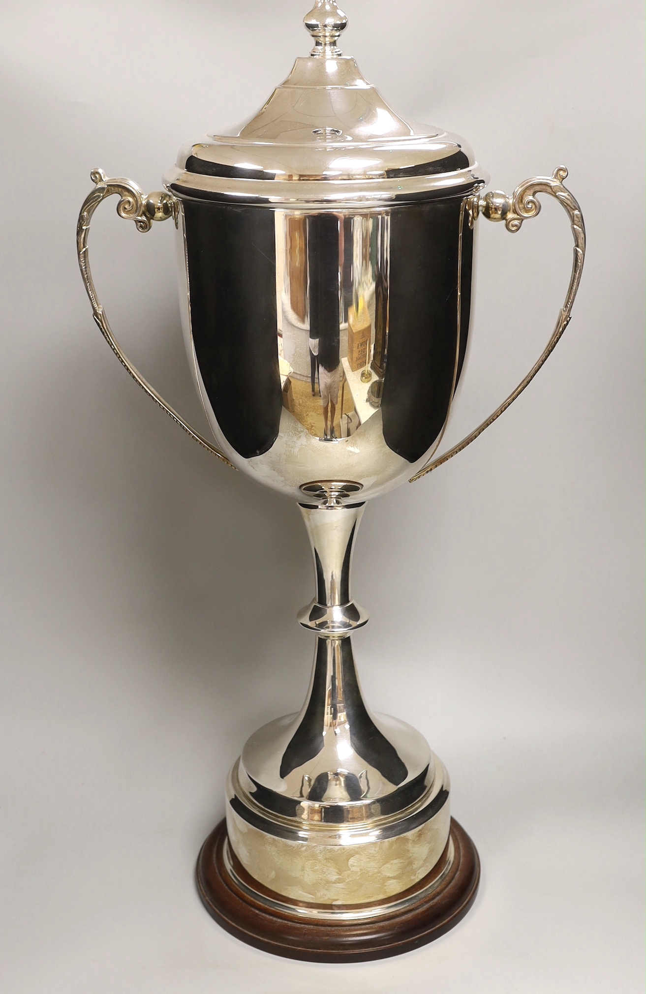 ‘The London Cup’, a large silver plated twin handled trophy and cover on circular wooden stand, 70cm high